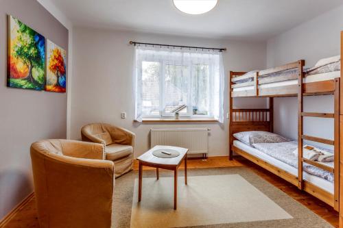 a bedroom with bunk beds and a chair and a table at Pension U Lípy in Rovečné