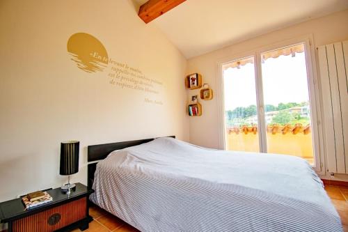 une chambre avec un lit et une grande fenêtre dans l'établissement Magnifique villa avec piscine à 2 pas du centre d'Aix, à Aix-en-Provence