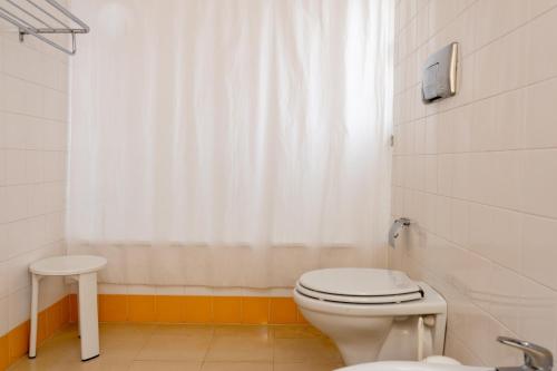 a bathroom with a toilet and a white shower curtain at Hotel Irmãs Dominicanas - Fátima by Flagworld Hotels in Fátima