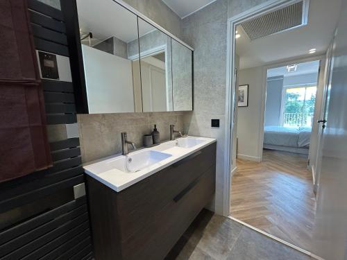 une salle de bain avec un lavabo et un miroir dans l'établissement Cannes Centre Cosy Appartement proche des plages, à Cannes