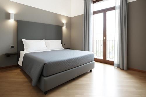 a bedroom with a bed and a large window at Piazza Carità in Naples