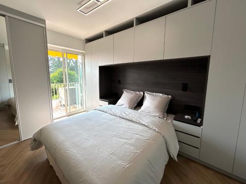 une chambre avec un grand lit blanc et une fenêtre dans l'établissement Cannes Centre Cosy Appartement proche des plages, à Cannes