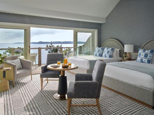 a hotel room with two beds and a table and chairs at Wequassett Resort and Golf Club in East Harwich
