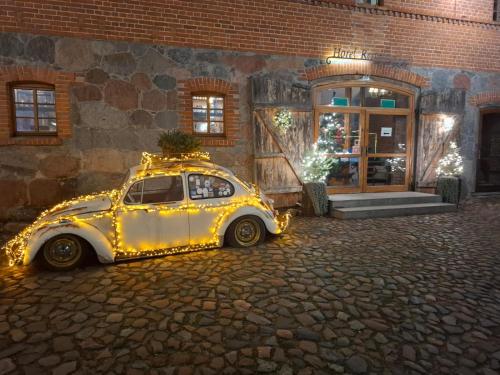 a car decorated with lights is parked in front of a building at Pałac Spichrz in Borcz