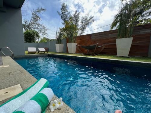 a swimming pool with blue water in a yard at La Mer Luxury Villa - Private Pool Langkawi in Pantai Cenang