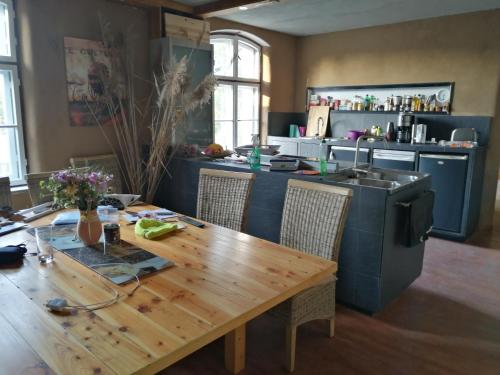 a kitchen with a wooden table with chairs and a sink at Wochenend-Auszeit in Möckern