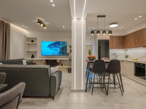 a living room with a couch and a table with chairs at Ergina Apartments Gournes Studio & Family Apartment in Gournes