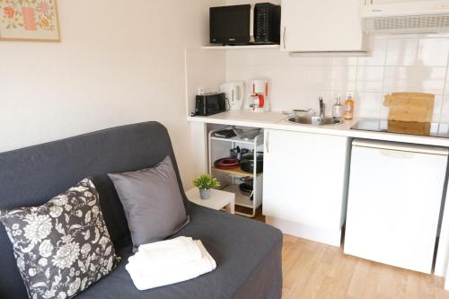 a living room with a couch and a kitchen at Studio L'ancre Crielloise in Criel-sur-Mer