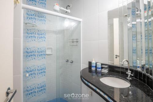 a bathroom with a glass shower and a sink at Aptos completos na melhor localização e a passos do mar de Guarapari - STP in Guarapari