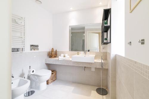 Un baño con lavabo, inodoro y espejo. en Palais de la rose 3, en Menton