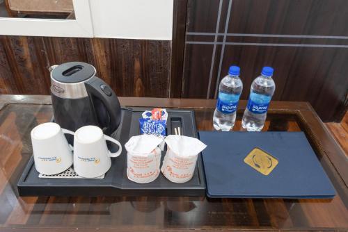 a tray with cups and water bottles on a table at Hotel RK Residency Vasundhara Ghaziabad Delhi NCR in Ghaziabad