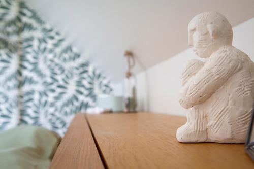 a statue of a person sitting on a table at Le repaire de Mélusine - Gîte de charme et love room in Sainte-Marie-Cappel