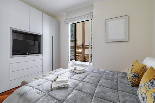 Un dormitorio con una cama grande y un televisor. en Palais de la rose 3, en Menton