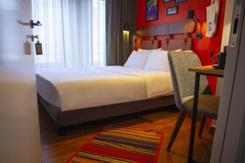 a bedroom with a bed and a desk and a chair at The Abies in Canakkale