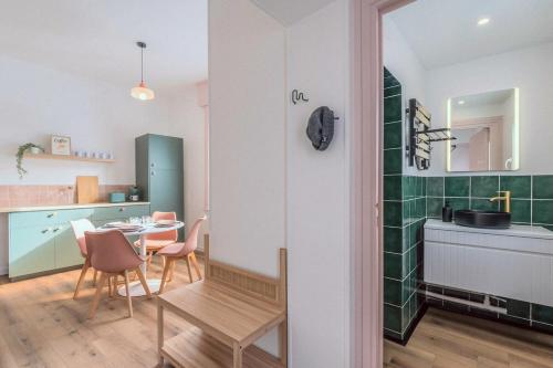 une cuisine et une salle à manger avec une table et des chaises dans l'établissement Cocon rétro 70s - 4p - Cœur Douai, à Douai