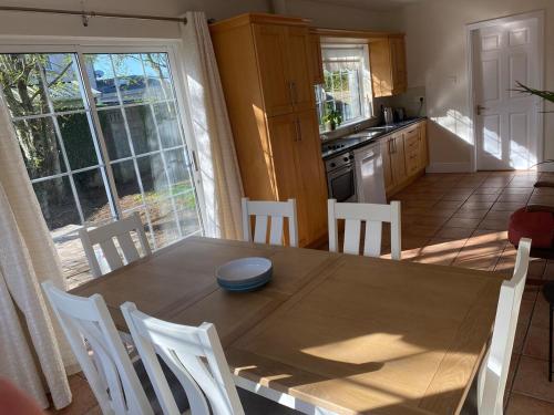 a kitchen and dining room with a wooden table and chairs at Bungalow in Clerihan in Clonmel