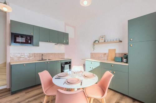 une cuisine avec une table et des chaises dans une cuisine dans l'établissement Cocon rétro 70s - 4p - Cœur Douai, à Douai