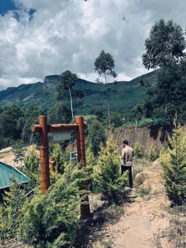 a man standing on a dirt road with trees at Aden Valley Resort in Kanthalloor