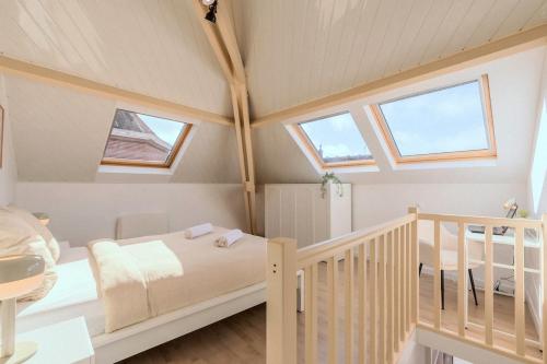 - une chambre avec un lit et un escalier avec des fenêtres dans l'établissement Cocon rétro 70s - 4p - Cœur Douai, à Douai