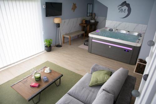 a living room with a couch and a bed at Le repaire de Mélusine - Gîte de charme et love room in Sainte-Marie-Cappel