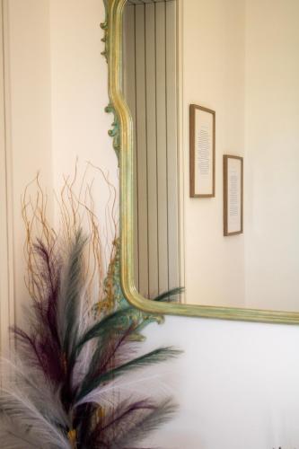a mirror on a wall with a plant at Casa Baí in Torre Nubia