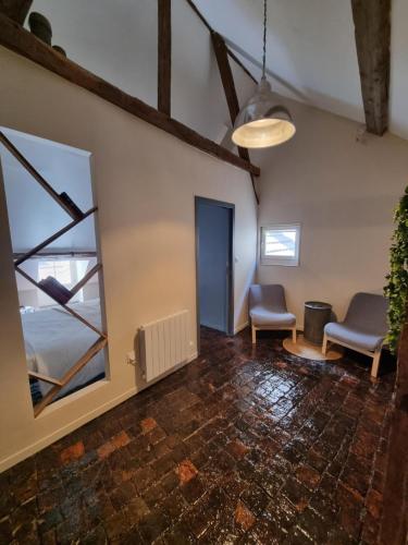 une pièce vide avec deux chaises et un miroir dans l'établissement L'appartement de Georges, à Auxerre