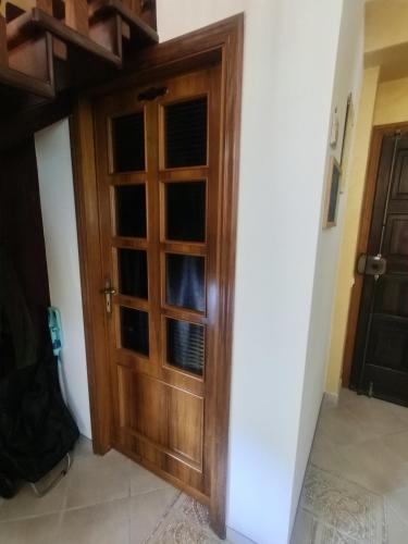 a wooden door in a room with a white wall at Vicky's B&B by V in Papasidero