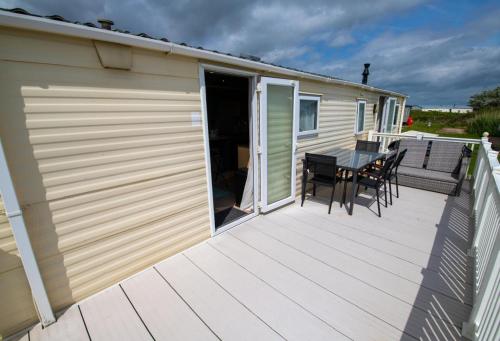 a large deck with a table and chairs on it at WW213 - 4 bed, Parkdean Camber in Camber