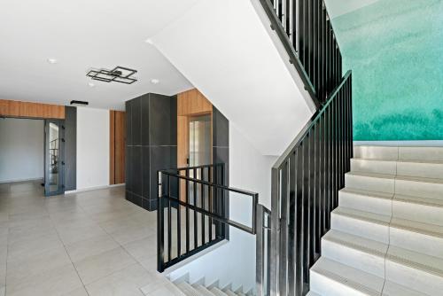 a staircase in a house with a painting on the wall at HoliApart in Nautikka Park - blisko plaży, kids club, plac zabaw, garaż podziemny in Krynica Morska