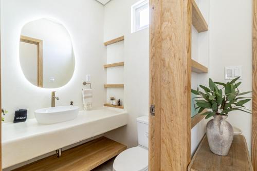 un baño con lavabo y espejo en Barefoot Bungalow and Pool Club at Mahogany Bay, en San Pedro