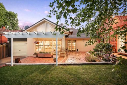 a house with a white pergola in the yard at Botanical gardens retreat in Albury