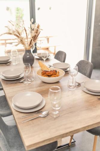 a wooden table with a plate of food and wine glasses at Spacious house in Olhao in Quelfes