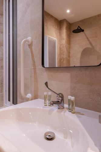 a white sink in a bathroom with a mirror at Roel Boutique B&B in Cospicua
