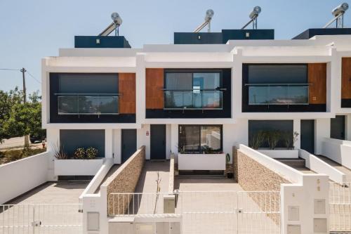a large white building with black windows at Spacious house in Olhao in Quelfes