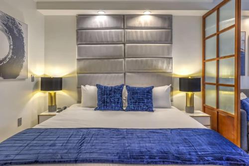 a bedroom with a large bed with blue pillows at MGM Grand Vegas Strip 16th Floor Renovated Suite in Las Vegas
