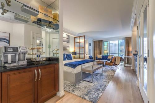 a living room with a couch and a kitchen with a microwave at MGM Grand Vegas Strip 16th Floor Renovated Suite in Las Vegas