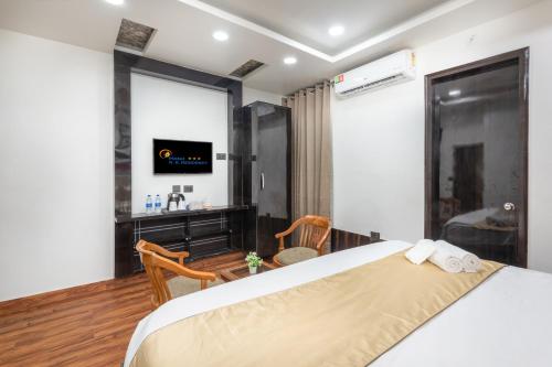 a bedroom with a large bed and a television at Hotel RK Residency Vasundhara Ghaziabad Delhi NCR in Ghaziabad