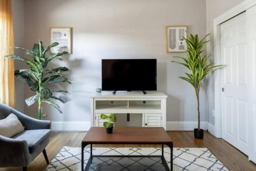 a living room with a tv on a white stand at Charming Theater District 1Br in Boston