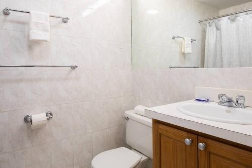 a white bathroom with a toilet and a sink at Charming Theater District 1Br in Boston