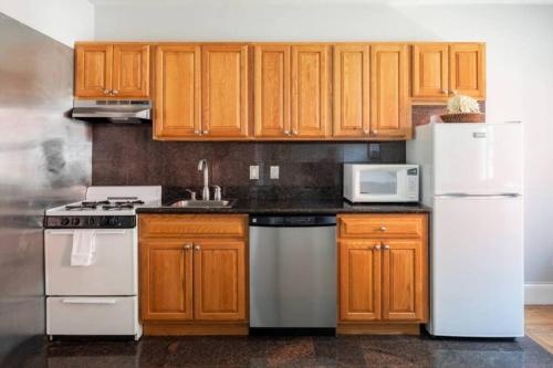 a kitchen with wooden cabinets and a white refrigerator at Charming Theater District 1Br in Boston