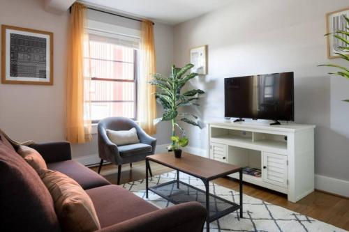 a living room with a couch and a tv at Charming Theater District 1Br in Boston