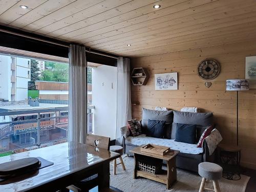 un salon avec un canapé et une table dans l'établissement Appartement rénové 2 chambres, balcon sud, à 50m des pistes et commerces - La Toussuire - FR-1-416-145, à La Toussuire