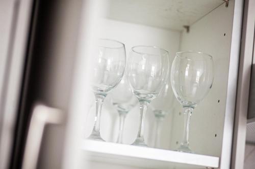 a row of wine glasses sitting on a shelf at The Cedar - Free Parking, Netflix, Near M1, M69 in Enderby