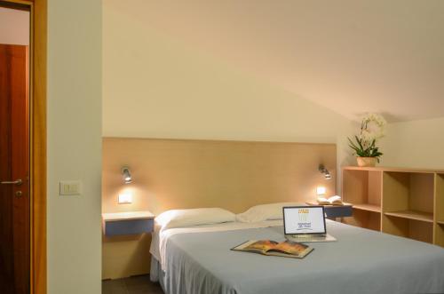 a hotel room with a bed with a laptop on it at Residence Dei Fiori in Pietra Ligure