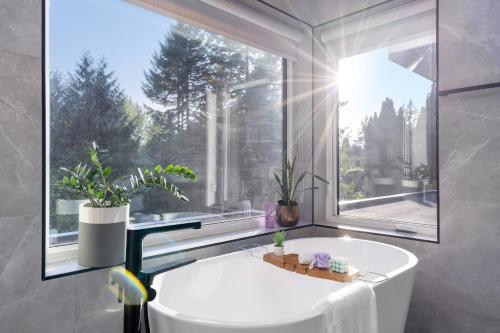 un bagno con vasca e una grande finestra di 2505 Edgemont Blvd.- Anupoju a North Vancouver