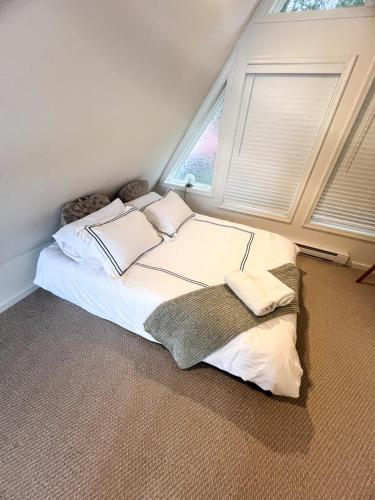 a bedroom with a large bed with two pillows at Lakefront A-frame Hot Tub, Dock, Kayaks, Games in Lake Ariel