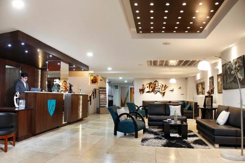a lobby with couches and chairs and a bar at Hotel Valgus in Cuenca