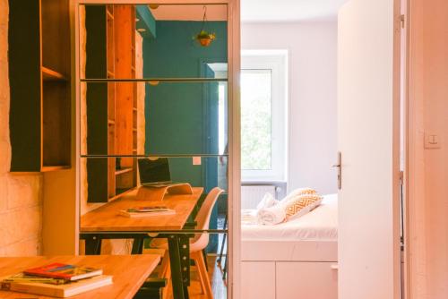 une chambre avec un bureau et une chambre avec un lit dans l'établissement A découvrir - L'Emergence, à Strasbourg
