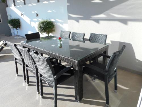 a black dining room table and chairs with a glass top at Villa Palladium in Makarska