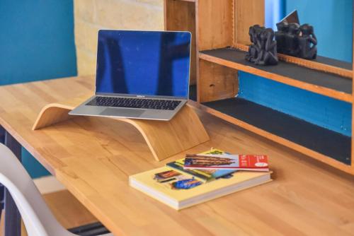 un ordinateur portable installé au-dessus d'un bureau en bois dans l'établissement A découvrir - L'Emergence, à Strasbourg
